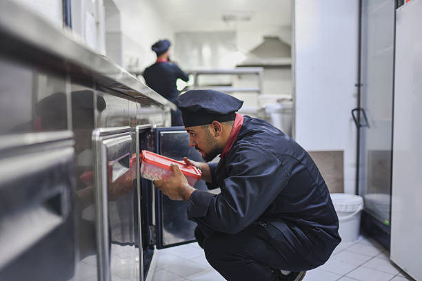 istock Chef Kneeling And Checking Storage In A Professional Kitchen For Efficient Food Preparation 2243302767