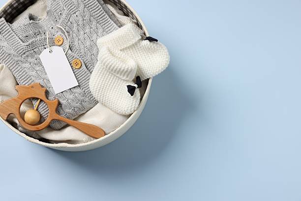 istock Different baby accessories and clothes in box on light blue background, top view. Space for text 2243305516