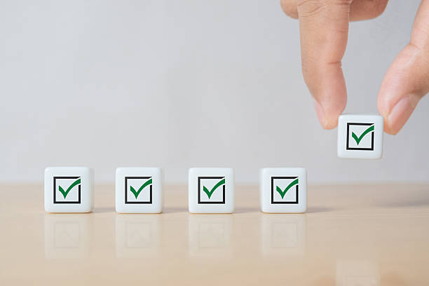 istock Dice checklist and green check mark icon with hand on table background. Business task sign appointment schedule concept. Businessman placing correct evaluation satisfaction checkbox symbol 2243309441