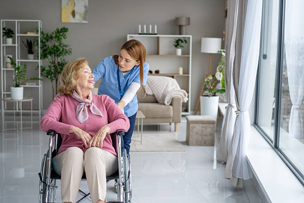 istock Elderly woman smiles while being assisted by a nurse 2243310458
