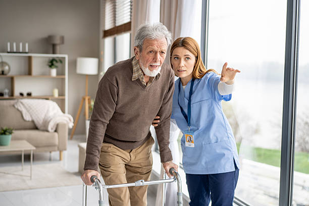 istock Caregiver Assisting Elderly Man with Walker in Bright Home 2243310480