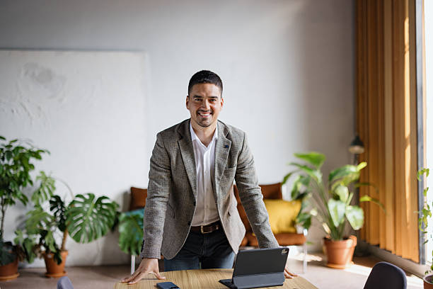 istock Confident businessman smiling in modern office with tablet 2243311046