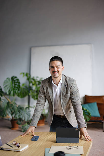 istock Businessman smiling, standing confidently at office desk 2243311068