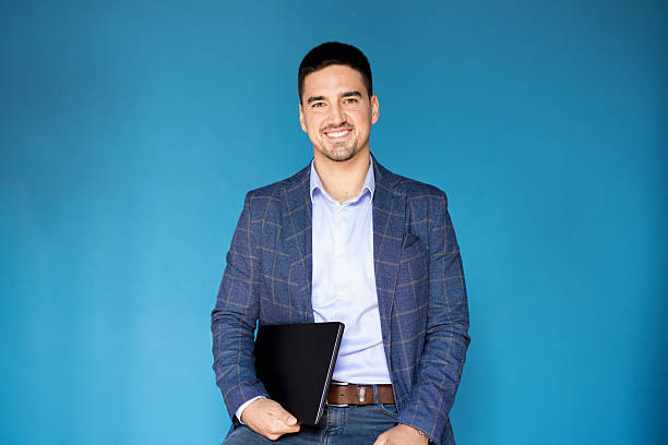 istock Young businessman holding laptop smiling at camera 2243311314