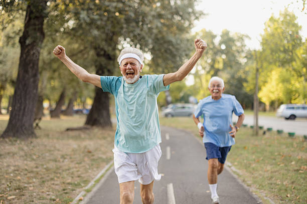 istock Senior man winning race with arms raised in park 2243315780
