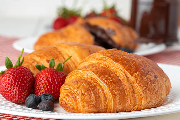 istock Fresh croissant decorated with berries on white wooden board 2243317329