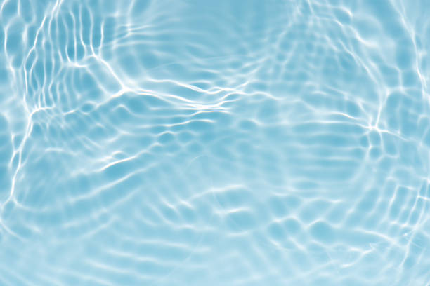 istock Blue water with ripples on the surface. Defocus blurred transparent blue colored clear calm water surface texture with splashes and bubbles. Water waves with shining pattern texture background. 2243324652