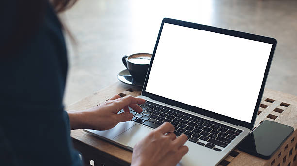 istock Laptop computer blank screen mockup. Woman working on laptop with empty screen for advertising, contact business search information on desk at coffee shop. marketing and web design template 2243325804