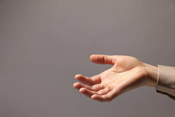 Female and male hands reaching toward each other extending a helping hand isolated on a white background. Handover