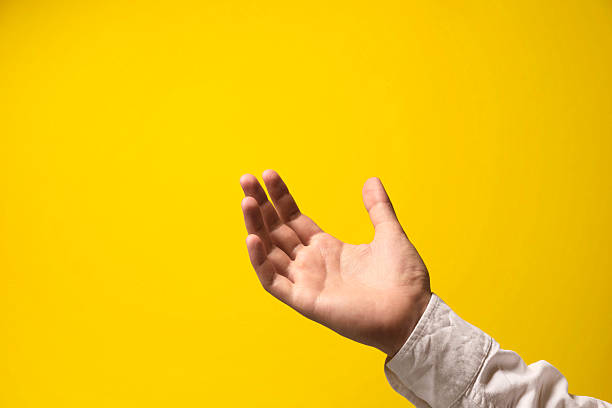 istock Man holding something in hand on yellow background, closeup. Space for text 2243328772