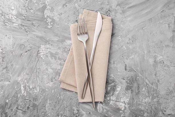 istock Elegant silver cutlery and kitchen towel on grey textured table, top view 2243329876