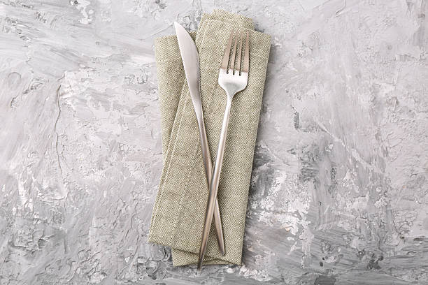 istock Elegant silver cutlery and kitchen towel on grey textured table, top view 2243329890