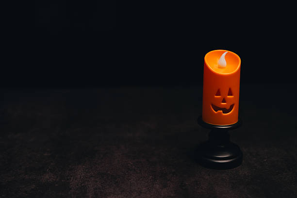 istock Halloween Candle Decoration with Jack-O-Lantern Face on Black Background for Festive Celebrations and Spooky Ambiance 2243338255