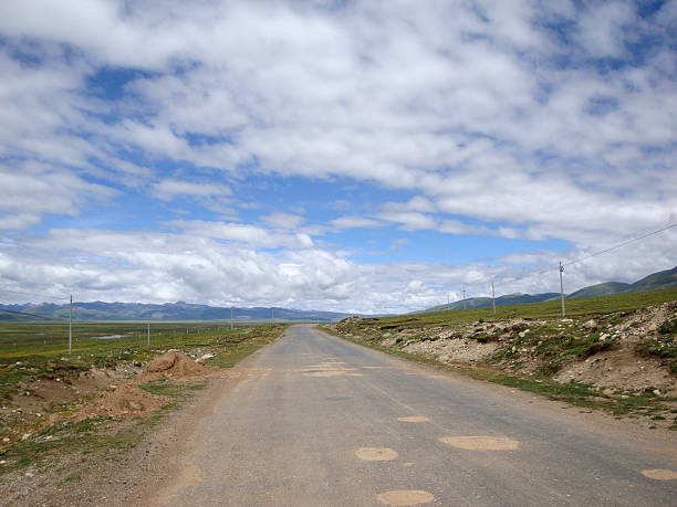 istock A scenic road under a blue sky with white clouds 2243343241
