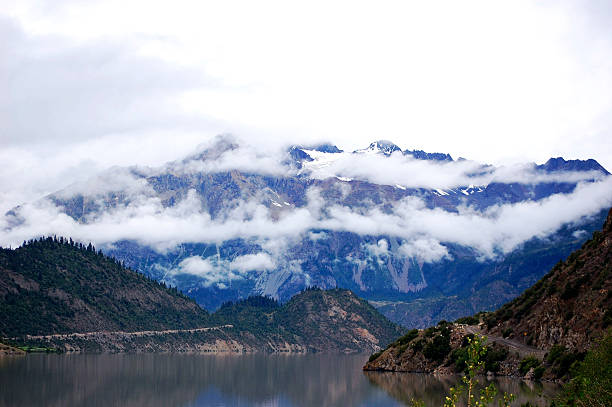 A picturesque scene of misty mountains and a serene lake with reflections, showcasing natural beauty.