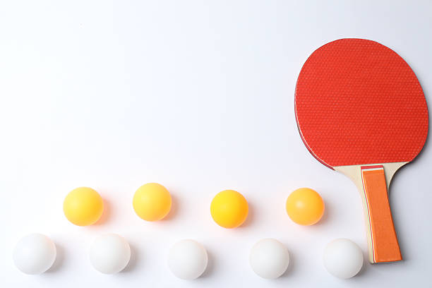 Smiling businessman playing table tennis with a colleague in break room. Man and woman playing ping pong in startup break room.