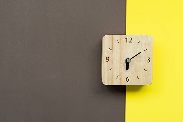 istock Retro alarm clock on brown and yellow table background, vintage 2243354292