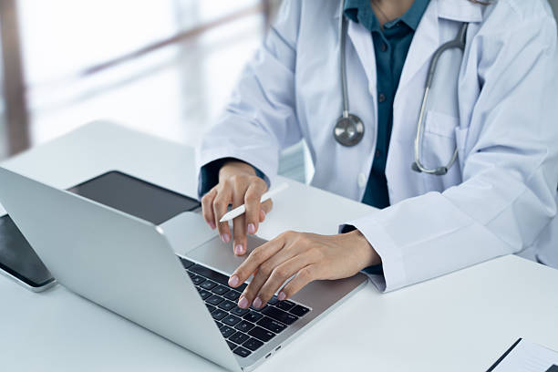 istock Close up, doctor working on laptop computer with digital tablet on office table. Female doctor searching the patient health information, using laptop and tablet. healthcare and medicine concept 2243355238