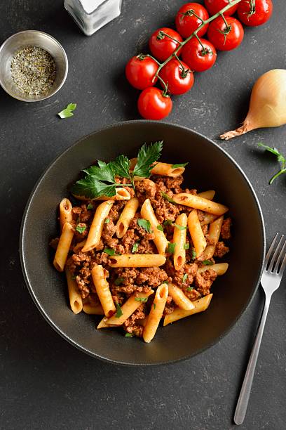 istock Penne pasta with minced meat, tomato sauce and greens 2243356682