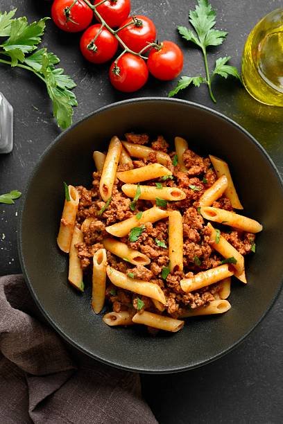 istock Penne pasta with minced meat, tomato sauce and greens 2243356694