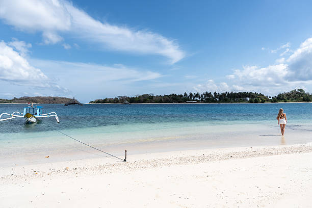 istock Woman walking into tropical ocean on paradise beach 2243359567