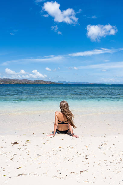 istock Woman relaxing on tropical beach enjoying ocean view 2243359571