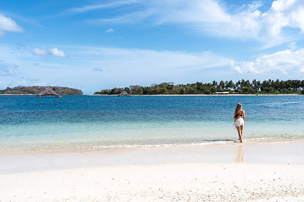 istock Woman walking on tropical beach during summer vacation 2243360043