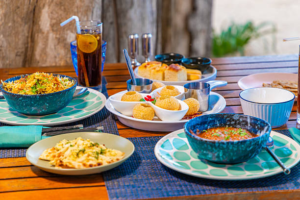 Vibrant Indian cuisine on rustic wooden table featuring biryani, curry