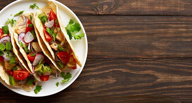 istock Tacos with vegetables and meat on wooden background 2243361097