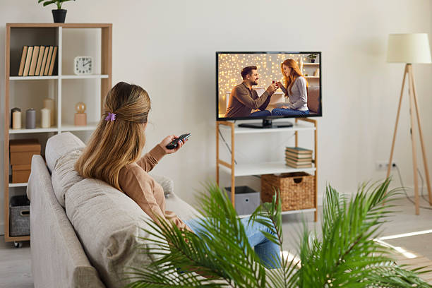 istock Young woman relax at home watching TV 2243361450