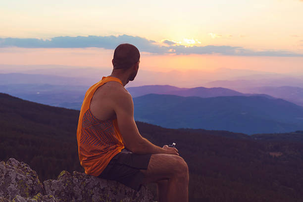 Man enjoying the sunset sky in the mountain