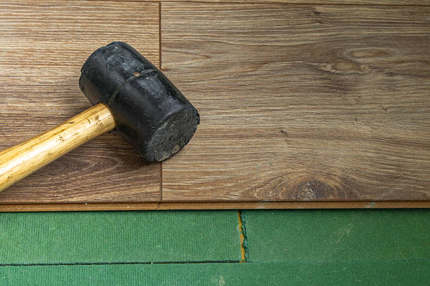 istock Installing Wooden Floor Panels with Rubber Mallet Home Renovation Work 2243363613