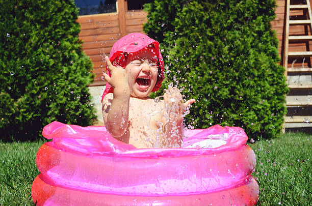 Children playing in inflatable baby pool.