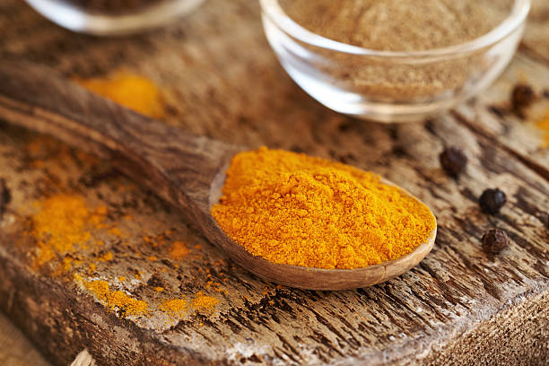 istock Turmeric root powder on a spoon with ground and whole black pepper in the background 2243370213