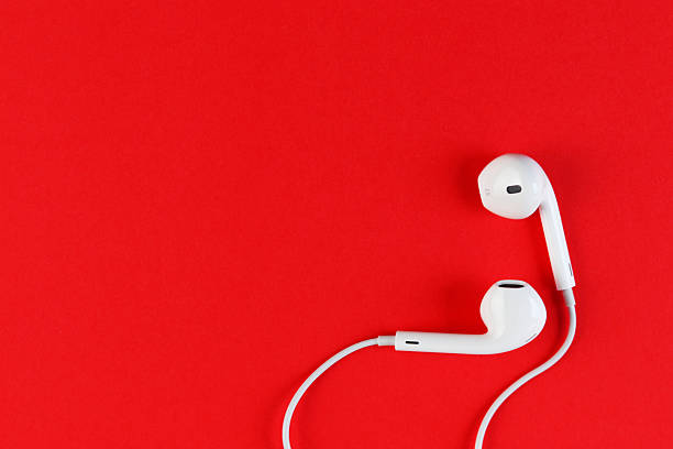 istock White wired earphones placed on a bright red background. 2243371745