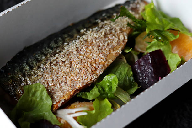 Baked mackerel with sesame seeds served with a fresh salad made of beetroot, orange slices, and lettuce. Healthy and nutritious meal option.