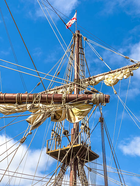 istock Tall ship mast with rigging and colorful signal flags against blue sky 2243376016