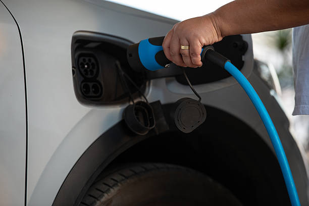 istock Hand Plugging Electric Vehicle Charging Cable into Car. 2243377102