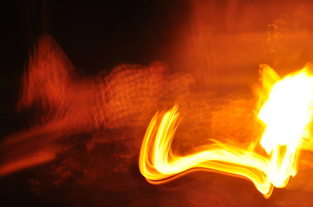 istock Fire dancing under the stars at a nighttime gathering near a campfire in the forest 2243379265