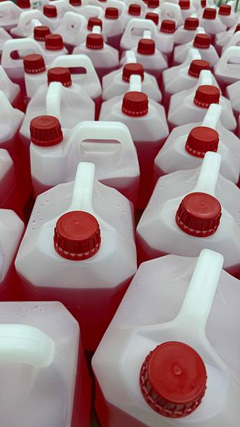istock Rows of red-capped plastic jugs with handles, suitable for industrial storage background 2243380399