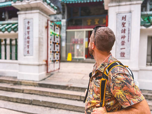 istock Tourist Exploring Urban Temple with Skyscrapers 2243382652