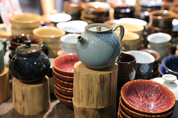 Hand is holding an  enamel teapot