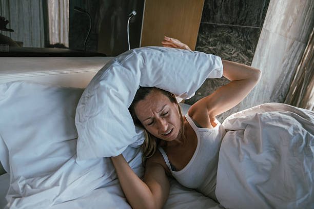 istock Woman Covering Ears with Pillow in Bed 2243383768