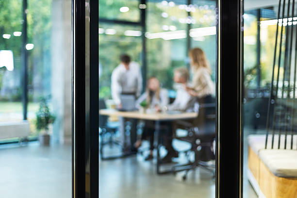 istock Businessmen blur in the workplace in office with computer or shallow depth of focus of abstract background, view from glass wall 2243385196