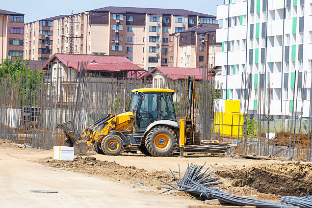Construction of a new residential area with apartment buildings using heavy construction equipment.