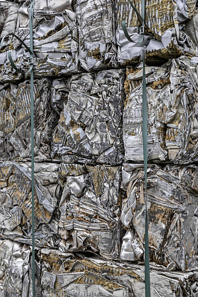 istock Stacks of crushed, foam-insulated metal panels compacted into rectangular bales, showing weathered textures and bound with industrial straps 2243386595