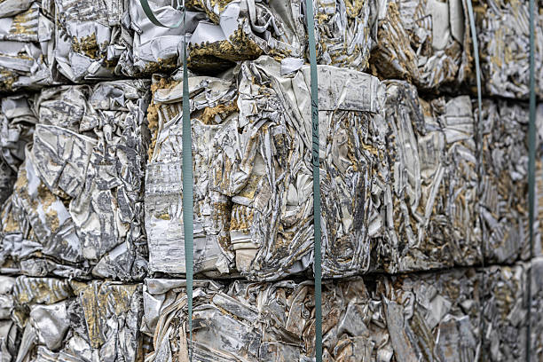 istock Stacks of crushed, foam-insulated metal panels compacted into rectangular bales, showing weathered textures and bound with industrial straps 2243386599