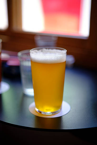 istock Cold beer in a pint glass on a coaster with soft bokeh background 2243389680