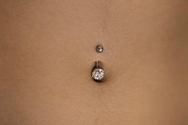 istock bird's-eye view of a woman's navel with a piercing 2243392702