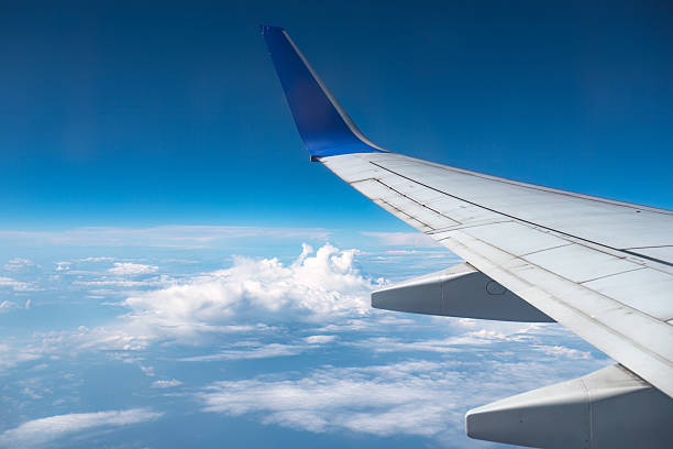 istock Airplane wing flying over a cloudy landscape on a sunny day 2243399788
